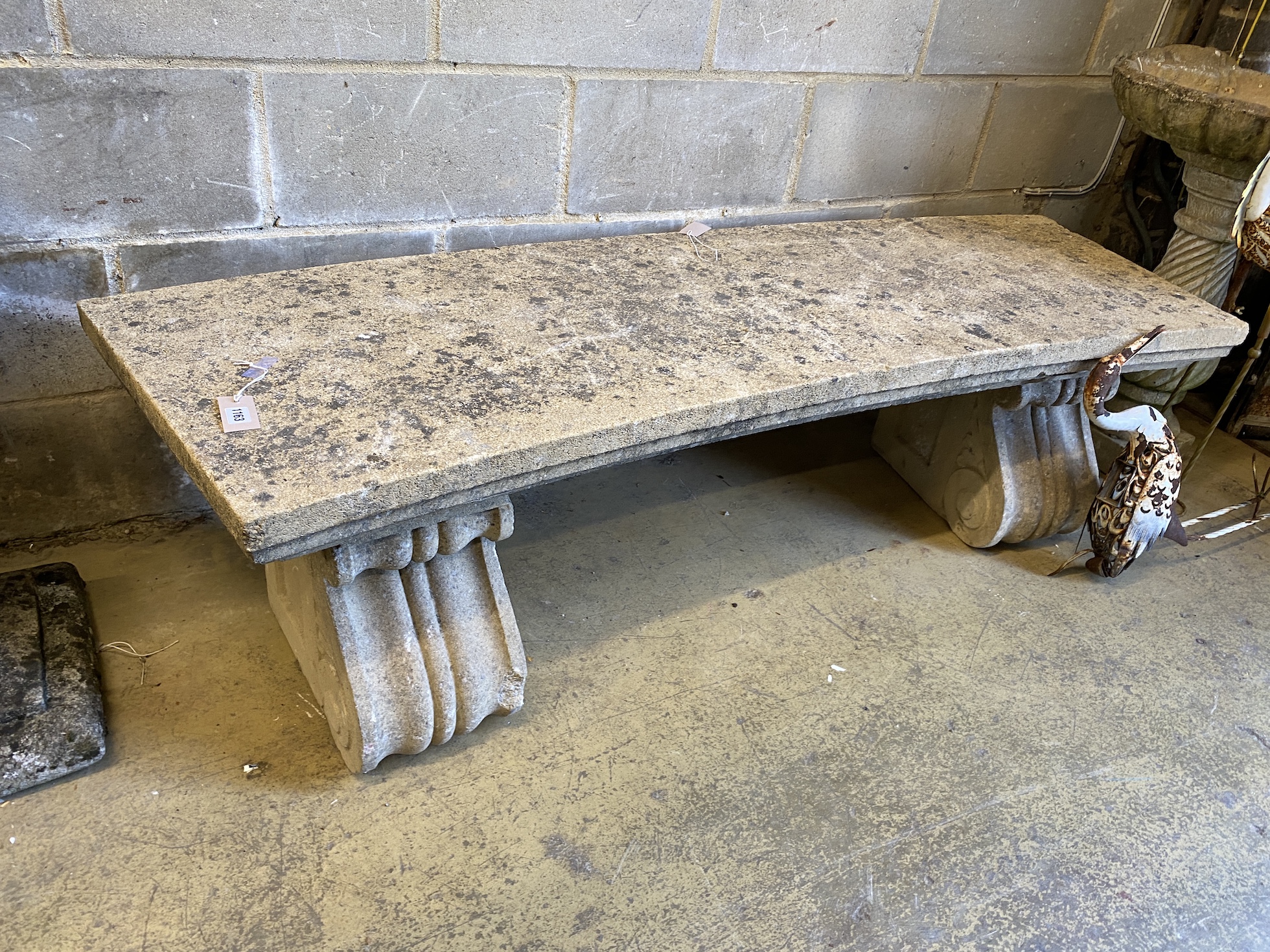A reconstituted stone curved garden bench, width 173cm, depth 54cm, height 45cm
